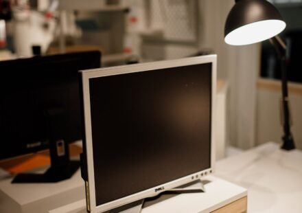 Computer monitor and desk lamp on a workspace desk