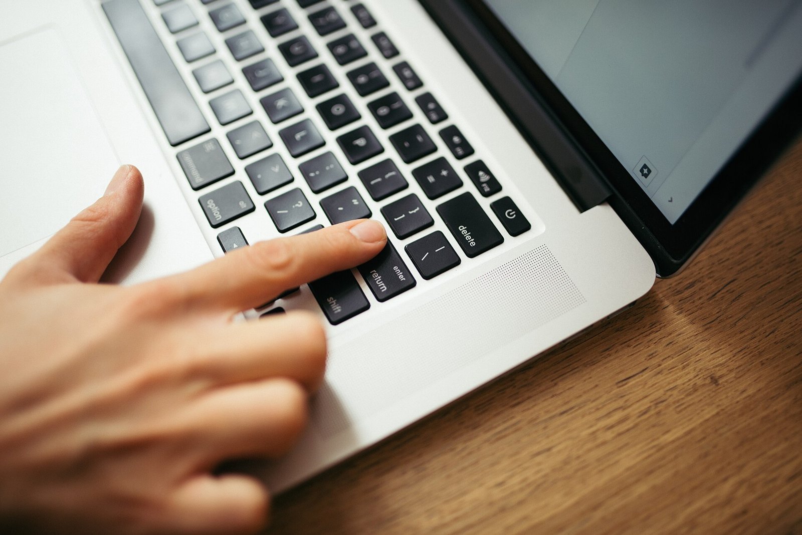 Hand pressing keys on a laptop keyboard
