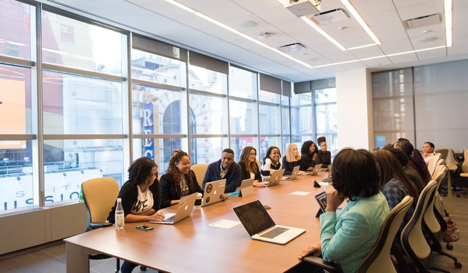 Jira Pricing 2026: Standard vs Premium, Annual Tiers and the Oct 13 Increase Team meeting around a long conference table with laptops open