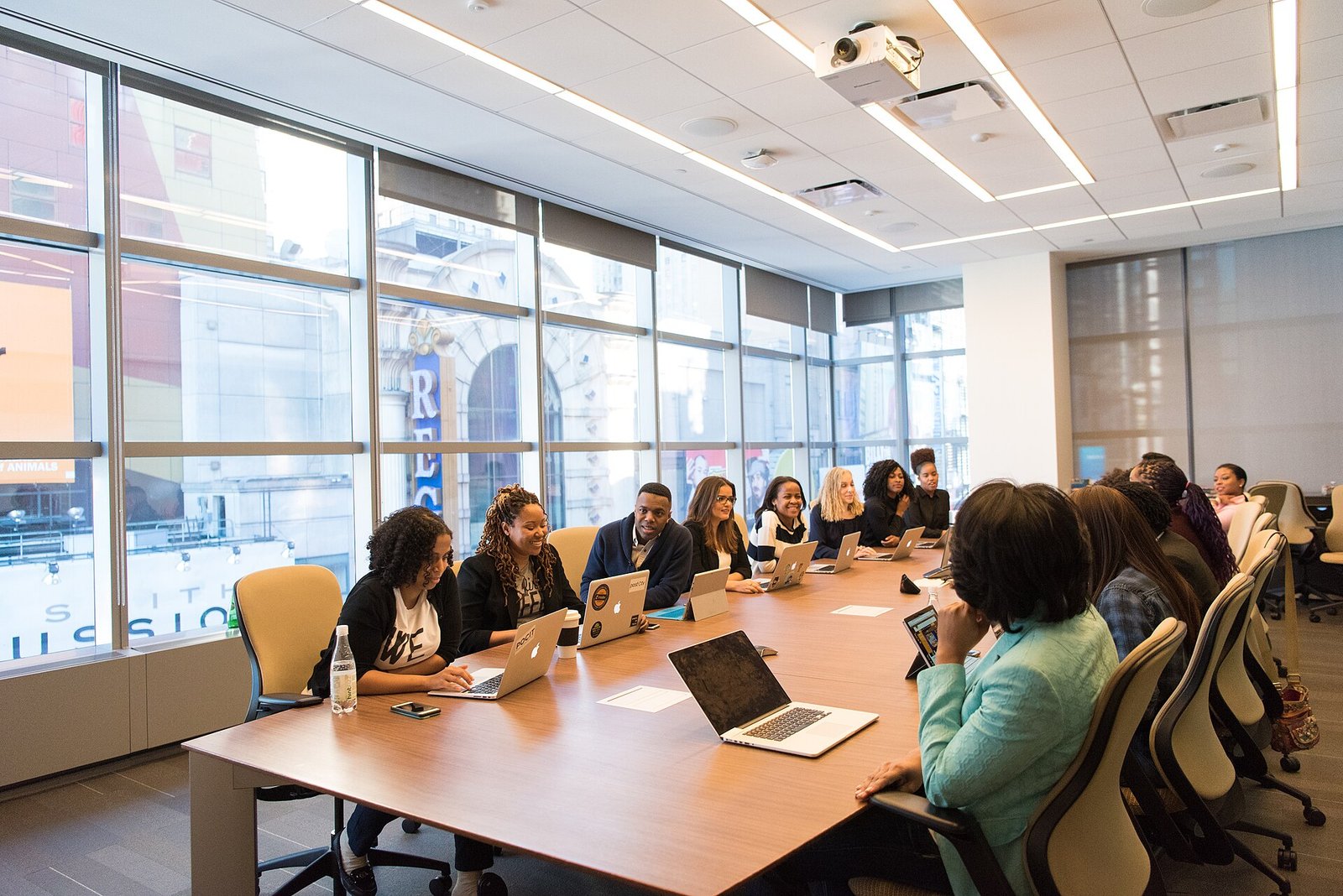 Team meeting around a long table with laptops open