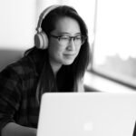 Person wearing headphones working on a laptop