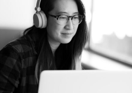 Person wearing headphones working on a laptop