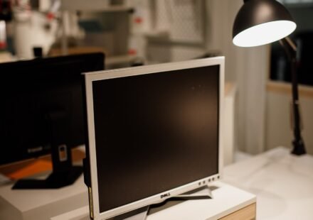 Office desk with a monitor and desk lamp