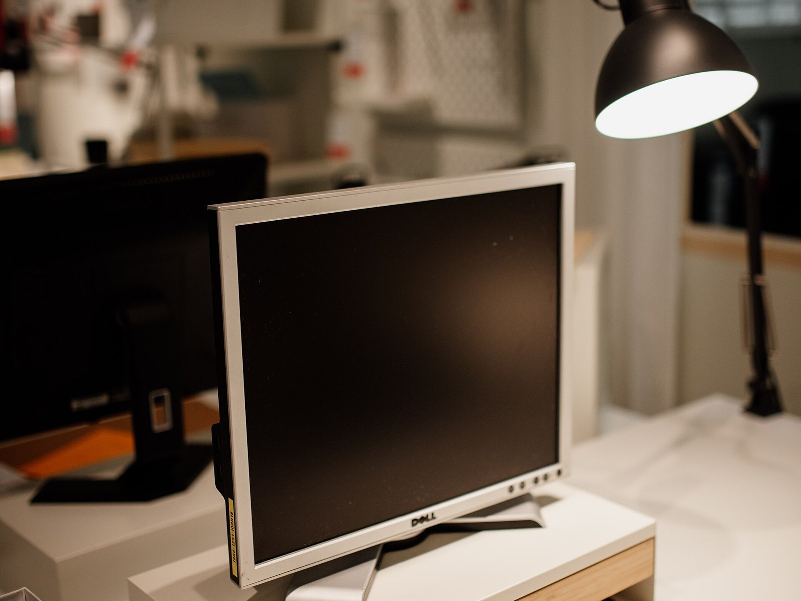Office desk with a monitor and desk lamp