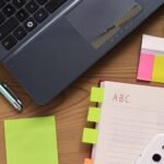 Laptop, notebook and pen on a wooden desk