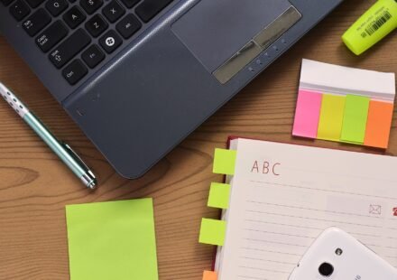 Laptop, notebook and pen on a wooden desk