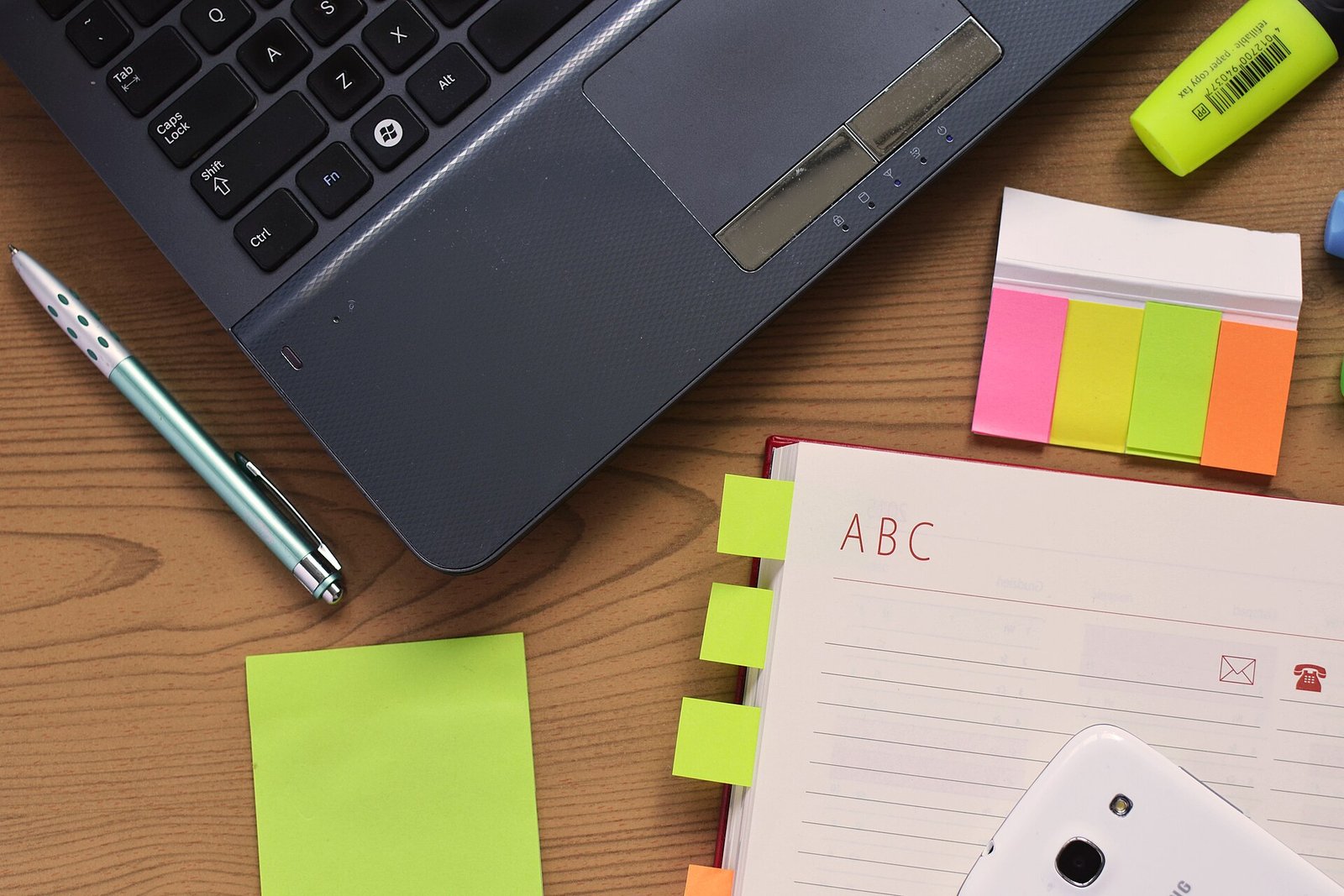 Laptop and notebook on a desk for planning a database structure