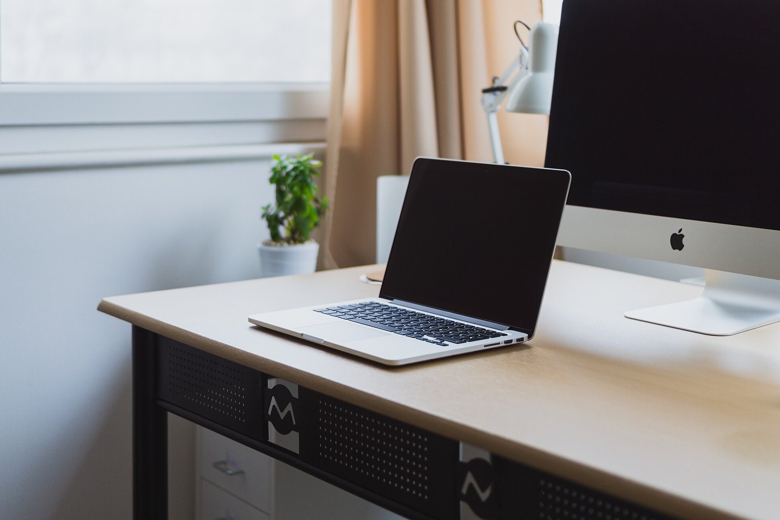 Laptop on a tidy desk next to a desktop monitor