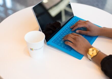 Person typing on a laptop at a small round table