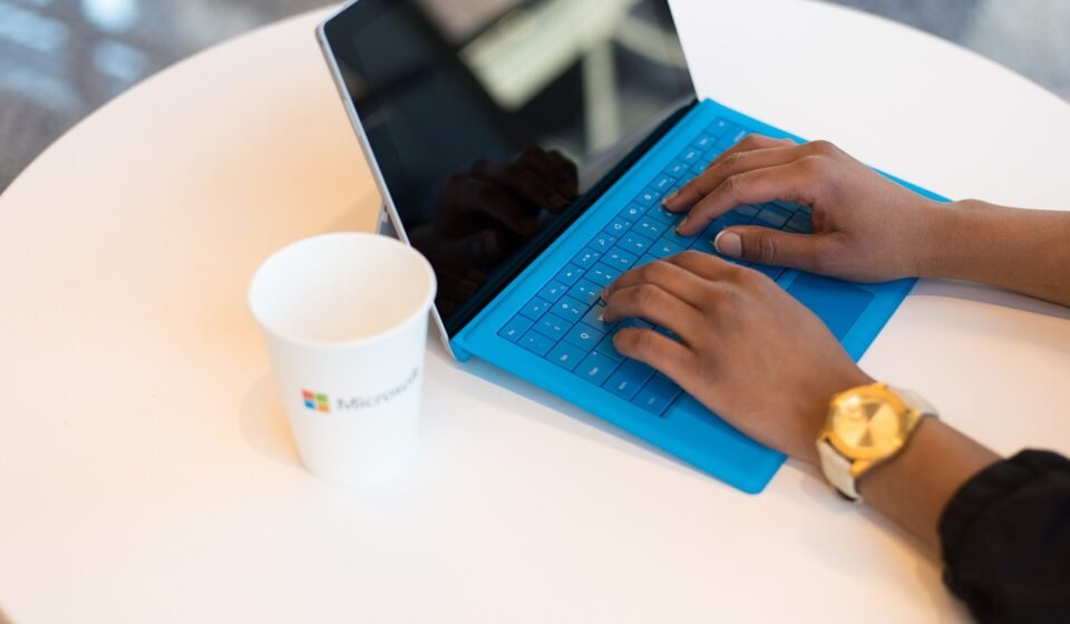Person typing on a laptop at a small round table