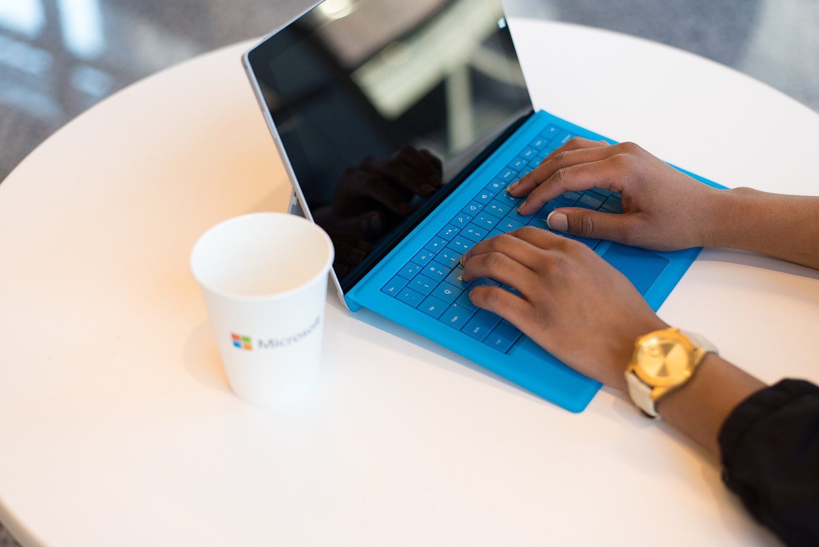 Person typing on a laptop at a small table