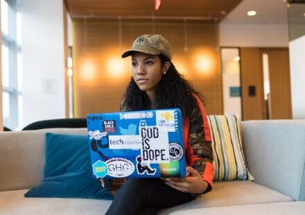 Laptop covered in developer stickers on a desk