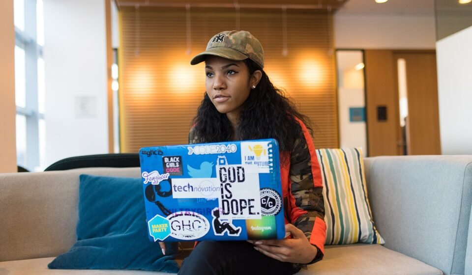 Linear vs GitHub Issues (2026): Who Should Track the Work? Laptop covered in developer stickers on a desk