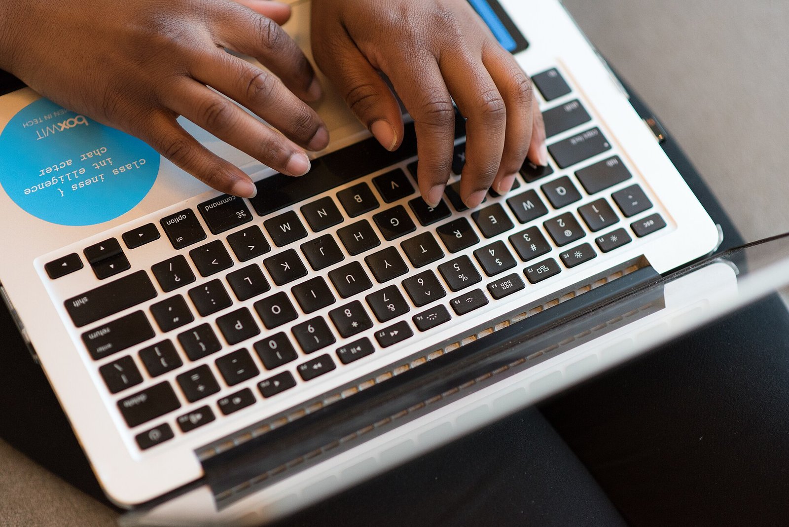 Hands typing on a laptop keyboard