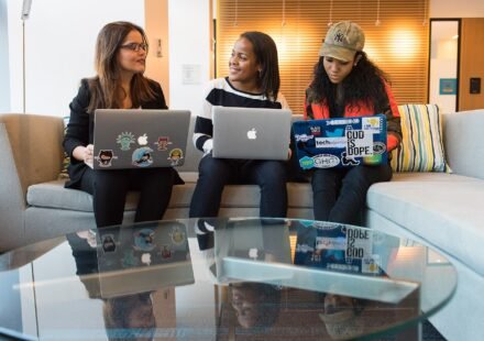 Small team working together on laptops on a couch