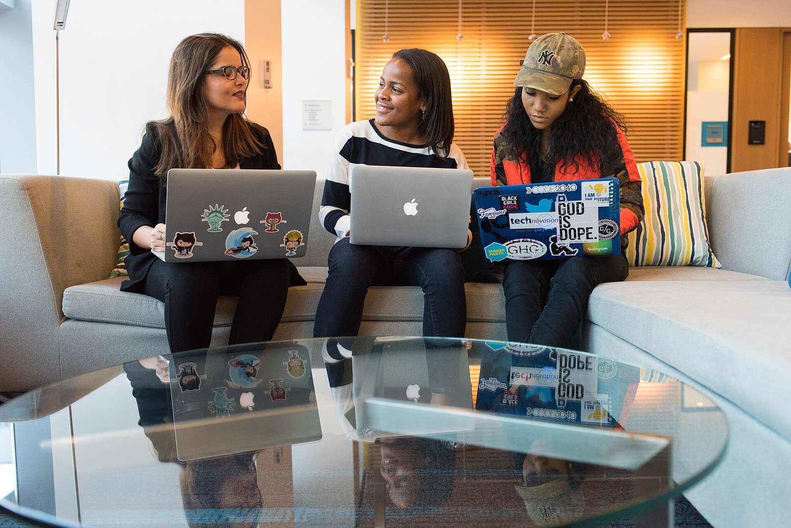 Small agency team working together on laptops on a couch
